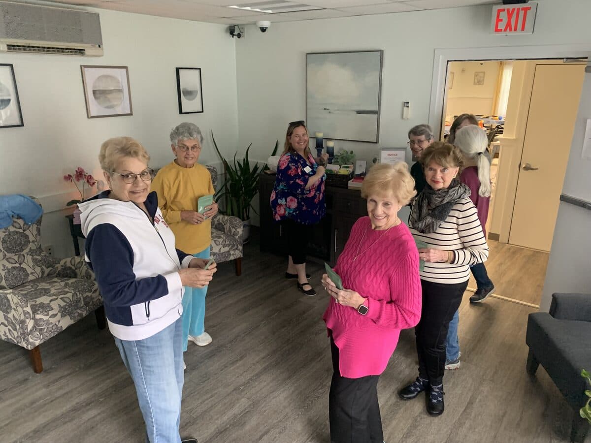 Group of smiling senior women gathering at a community center during a Moxie Mobility Training caregiver support event